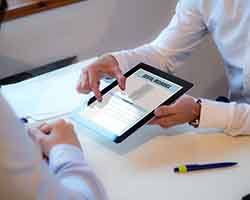 iPad that says “Dental Insurance” being held by a man in a white shirt