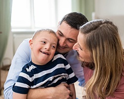 a special needs child smiling with his parents