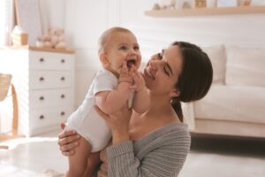 Happy mom playing with her baby